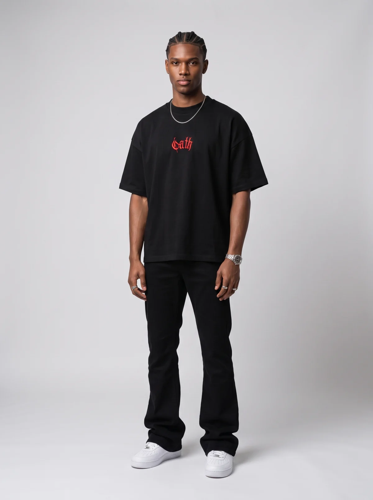 Fictional Black man modelling an oversized black T-shirt and trousers in a studio
